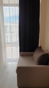 a bed in a room with a large window at Грибовка,Морской Аромат in Gribovka