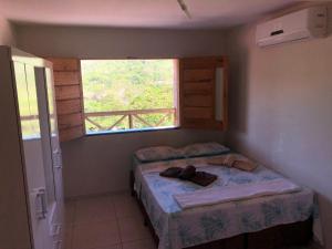 um pequeno quarto com 2 camas e uma janela em Barbosa acomodações. Lencois-BA em Lençóis