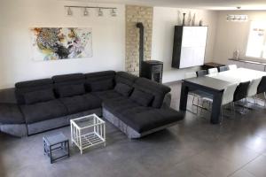 ein Wohnzimmer mit einem Sofa und einem Tisch in der Unterkunft Maison privative 5 Ch. 12 Pers. Piscine chauffée in Désertines