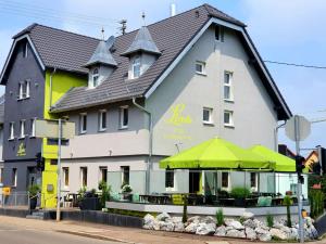 Un edificio con una sombrilla verde delante. en Hotel Landgasthof Linde, en Nürtingen