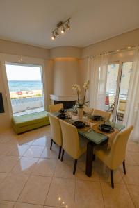 une salle à manger avec une table et des chaises et l'océan dans l'établissement Lemoni Luxury Residence in front of the Sea, à Kekhriaí