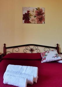een slaapkamer met een rood bed en 2 handdoeken erop bij Casa Azalea in Licata +10 foto's