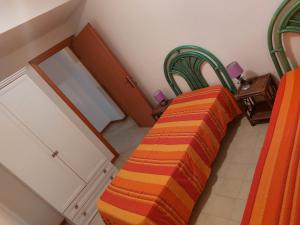 a bed with an orange and orange striped blanket in a room at Arboriamar in Marina di Sorso