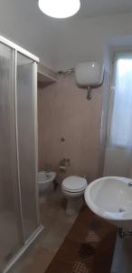 a bathroom with a shower and a toilet and a sink at GAIA Accommodation in Alghero