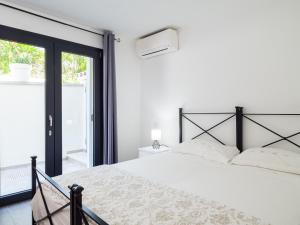 a white bedroom with a bed and a window at WLofts 13 by Klodge in Olbia