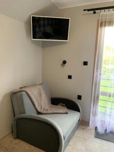 a room with a couch and a tv on the wall at U Halinki in Czorsztyn