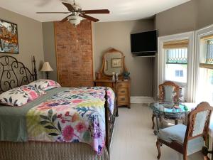 1 dormitorio con cama, tocador y espejo en Green Oaks B&B, en Niagara on the Lake