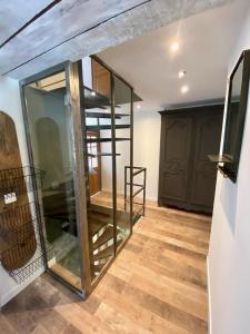 a room with glass doors and a wooden floor at Maison les pieds dans l'eau in Villefort