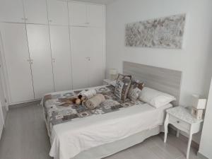 biała sypialnia z łóżkiem z białymi szafkami w obiekcie Almi Cabezo appartamento con terrazza El Médano w mieście El Médano