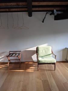 une chaise assise dans une pièce dotée d'un mur blanc dans l'établissement Le 33, à Bassano del Grappa
