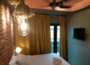 a bedroom with a ceiling fan and a bed and a light at Smile Hotel Danau Kota in Kuala Lumpur