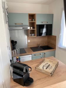 a kitchen with a table with a toaster on top of it at Appartement T2 les minimes chic et cosy in La Rochelle