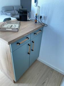 a desk in a room with a bed with a blue cabinet at Appartement T2 les minimes chic et cosy in La Rochelle