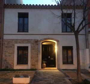 a large white house with a black door at Laindustria in Palamós