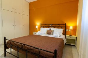 a bedroom with a bed with an orange wall at Elaionas in Leonidio