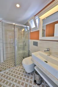 a bathroom with a shower and a toilet and a sink at Lora Kaş Hotel in Kas