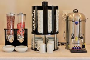 Eine Kaffeemaschine auf einer Theke mit Tassen und Tellern. in der Unterkunft Lora Kaş Hotel in Kaş
