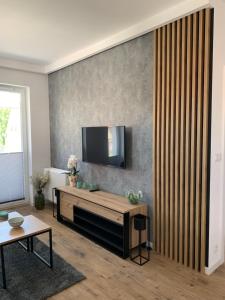 uma sala de estar com uma televisão de ecrã plano na parede em Apartament Joanna em Giżycko