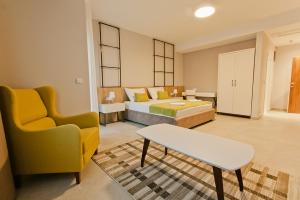 a bedroom with a bed and a couch and a chair at Hotel Hills Ulcinj in Ulcinj
