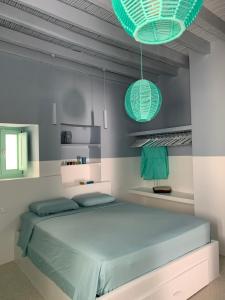 a bedroom with a bed and two green lights at IANUA Casa per Viaggiatori in Astypalaia