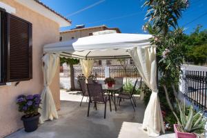 a white umbrella on a patio with a table and chairs at Irinis House in Komílion