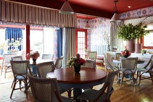 a dining room with tables and chairs and windows at The Cornell Inn, Lenox & The Berkshires in Lenox