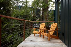 two wooden chairs sitting on a wooden deck at Middle Beach Lodge in Tofino
