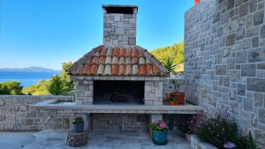 an outdoor fireplace with a brick wall at Apartments Tanja in Zavalatica