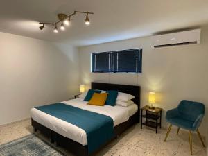 a bedroom with a bed and a blue chair at Vistalmar Ocean Suites in Oranjestad