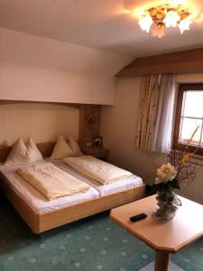 a bedroom with a large bed and a table at Egerbach Appartements in Schwoich