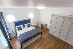 Schlafzimmer mit einem Bett mit blauem Kopfteil in der Unterkunft Brize Guesthouse in Tuzla