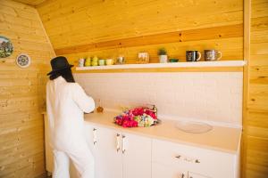 a woman in a hat is standing in a kitchen at Sunland-სანლენდი in Buknari