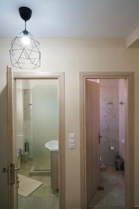 a bathroom with a door and a sink and a light at Charikleia's 1st floor appartment in Pelion in Volos