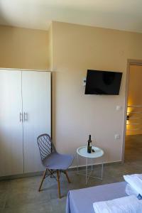 a room with a chair and a table and a tv at Charikleia's 1st floor appartment in Pelion in Volos