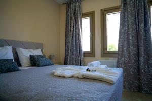 a bedroom with a bed with towels on it at Charikleia's 1st floor appartment in Pelion in Volos +7 photos