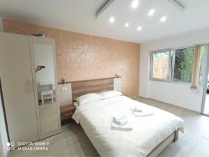 a bedroom with a large bed with two towels on it at Studio Dunja in Soko Banja