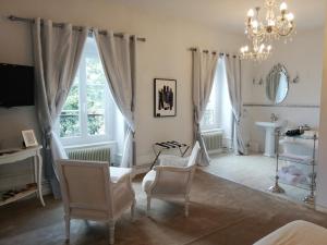 a living room with chairs and a chandelier at Château Les 4 Saisons in Saint-Cirgues-sur-Couze
