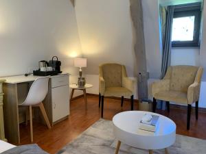 a living room with two chairs and a table at Le Noyer Résidence B&B in Le Bugue