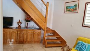 a wooden staircase in a living room with a television at Gorizia in Sainte-Anne