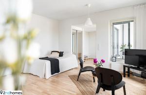 a white bedroom with a bed and a table and chairs at "Kanava" - New 1BR Apartment with Sauna, Balcony & Views, Hosted by 2ndhomes in Tampere