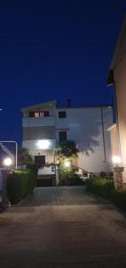 a large white building at night with lights at Apartments Sime in Sukošan