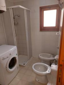 een badkamer met een wasmachine en een toilet bij Arboriamar in Sorso