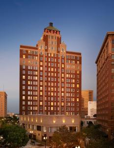 un grand bâtiment éclairé dans une ville dans l'établissement The Plaza Hotel Pioneer Park, à El Paso