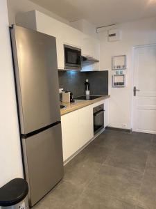 a kitchen with a stainless steel refrigerator at Anoli Lodge in Petit-Bourg