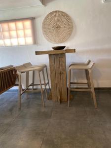 a table and two stools in a room at Anoli Lodge in Petit-Bourg