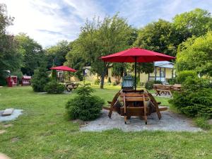 einen Picknicktisch mit einem roten Regenschirm in einem Park in der Unterkunft Feriendomizil Achtern Öwer in Lohme