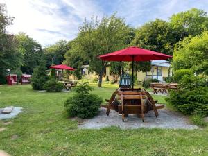 un tavolo da picnic con ombrellone rosso in un parco di Feriendomizil Achtern Öwer a Lohme