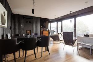 a dining room with black chairs and a table at Reelinki Seafront Villa Aava in Pori