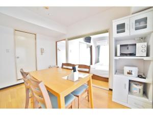 - une salle à manger avec une table, des chaises et un lit dans l'établissement HOTEL Nishikawaguchi Weekly - Vacation STAY 44799v, à Saitama