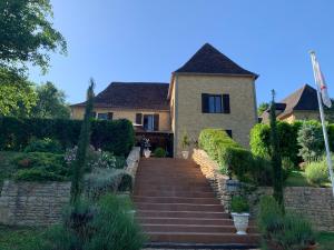 a house with a staircase in front of it at Le Noyer Résidence B&B in Le Bugue